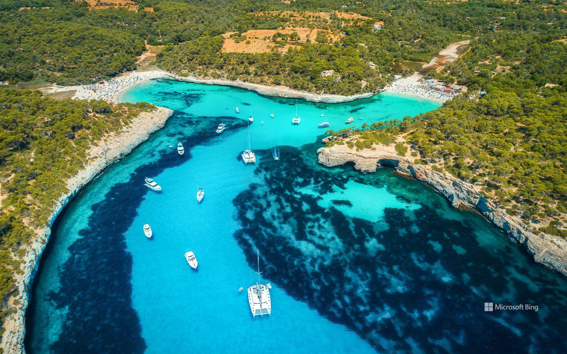 Aerial view of boats, luxury yachts and transparent sea on a sunny day in Mallorca, Spain