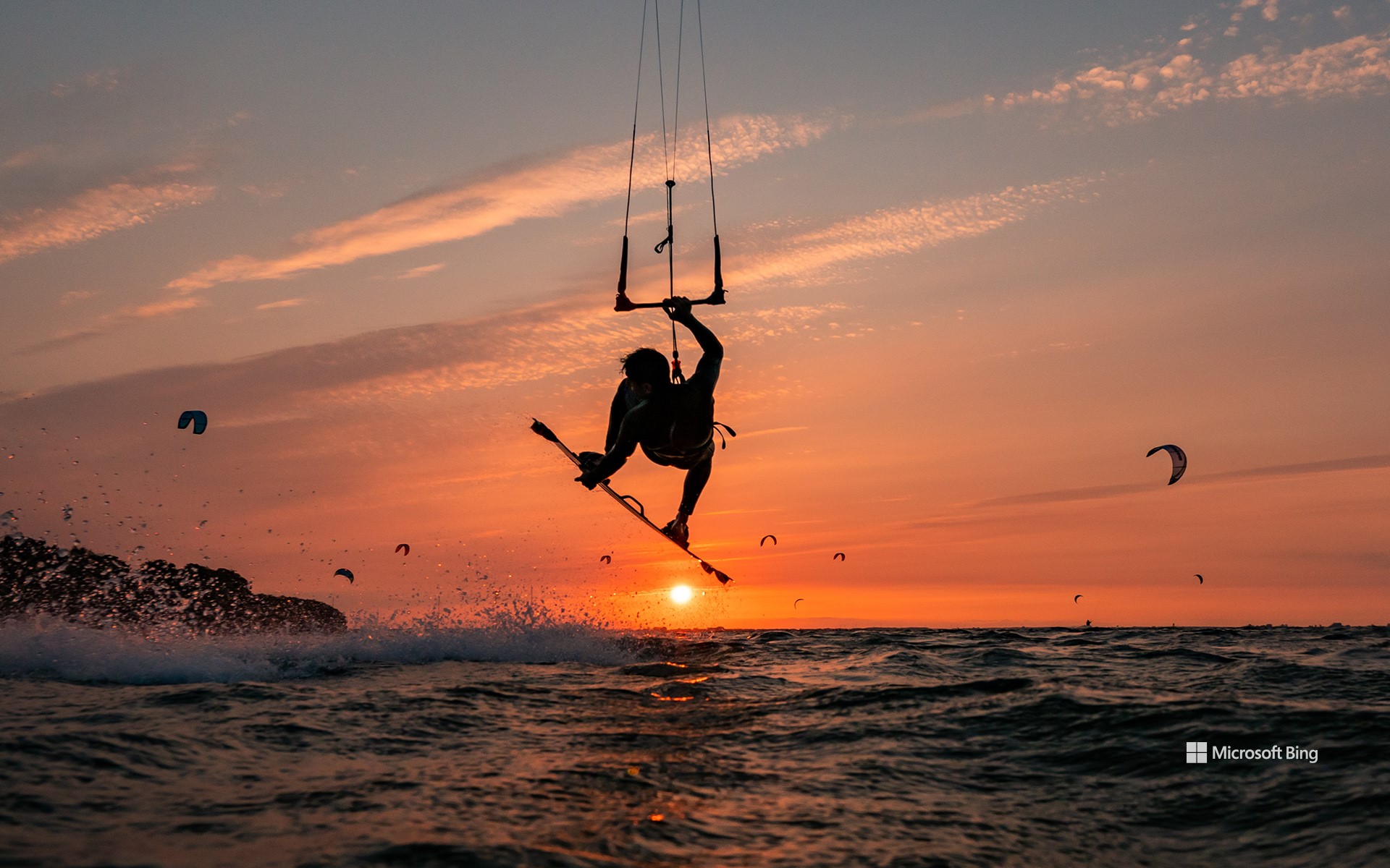 Silhouette of a jumping kitesurfer at sunset in the Baltic Sea