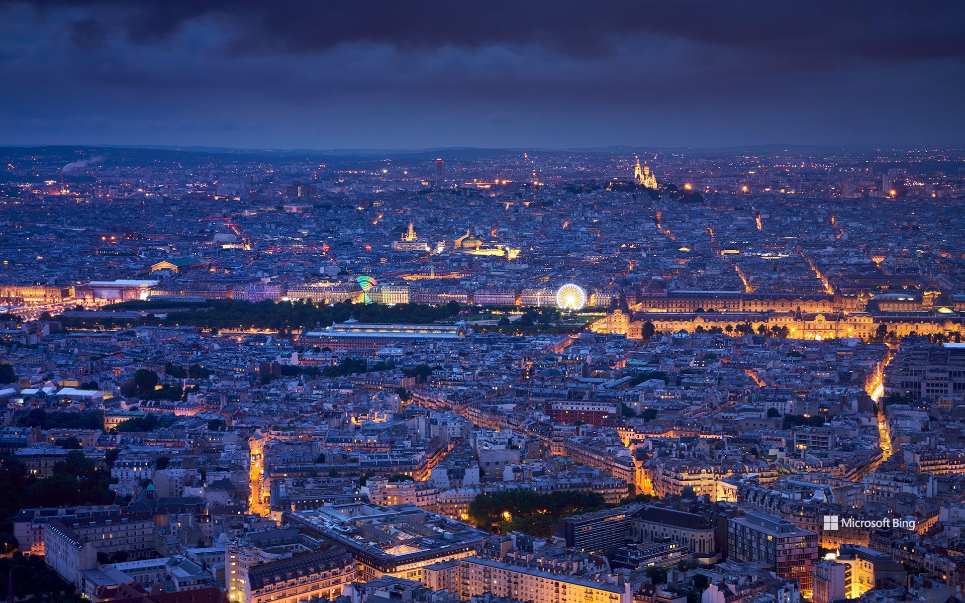 Aerial view of Paris at dusk with the Tuileries Garden, the Louvre and the Sacré-Cœur de Montmartre