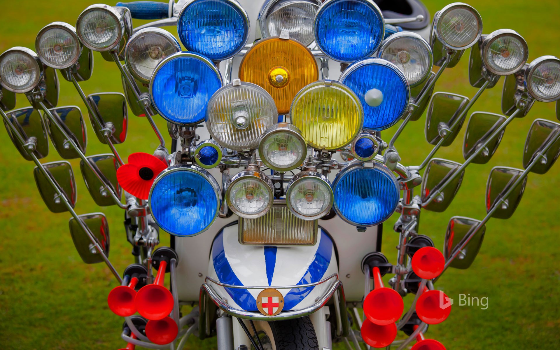 A scooter adorned with multiple mirrors, lights, and air horns
