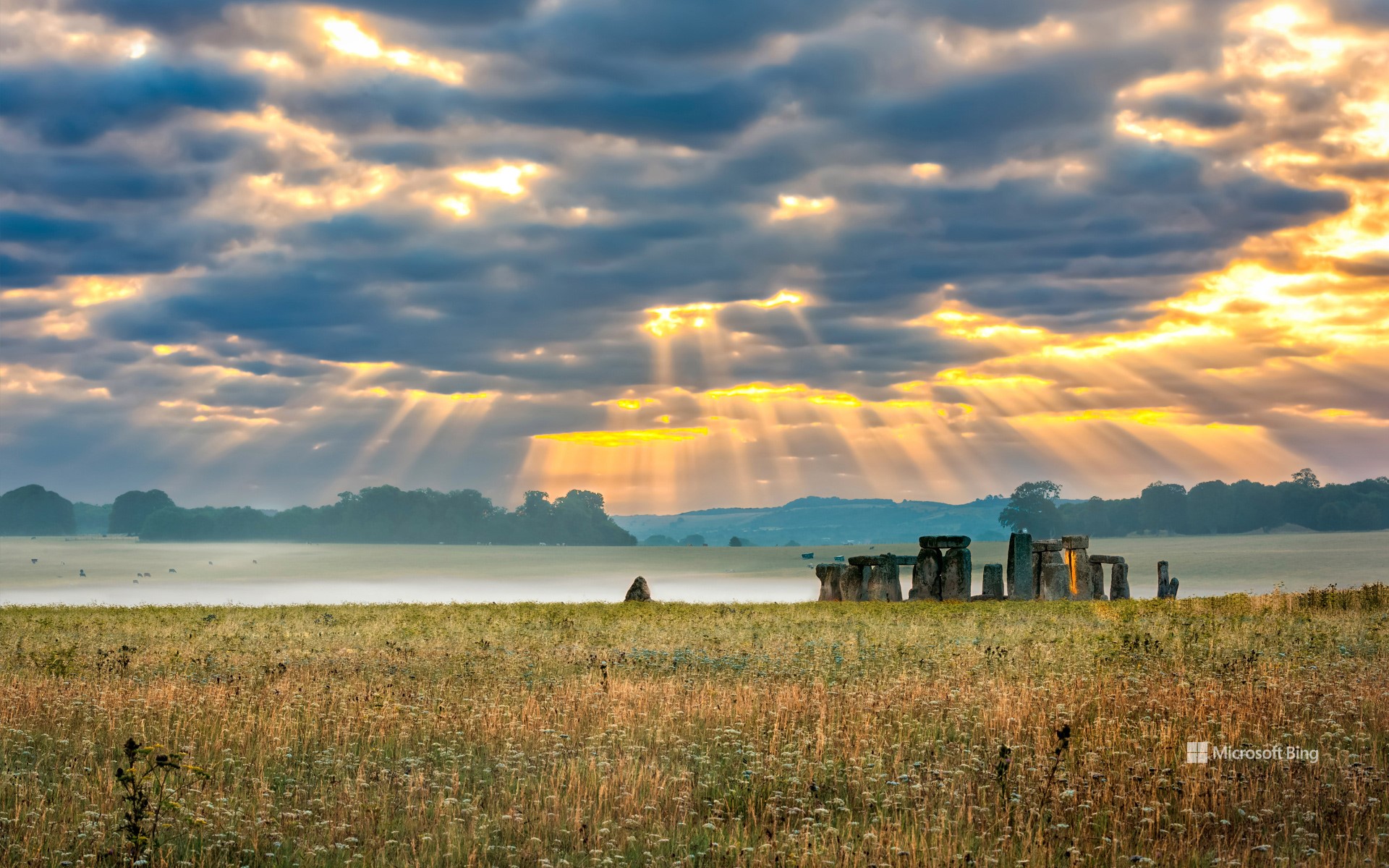 Cloudy sunrise over Stonehenge - prehistoric megalith monument arranged in circle.