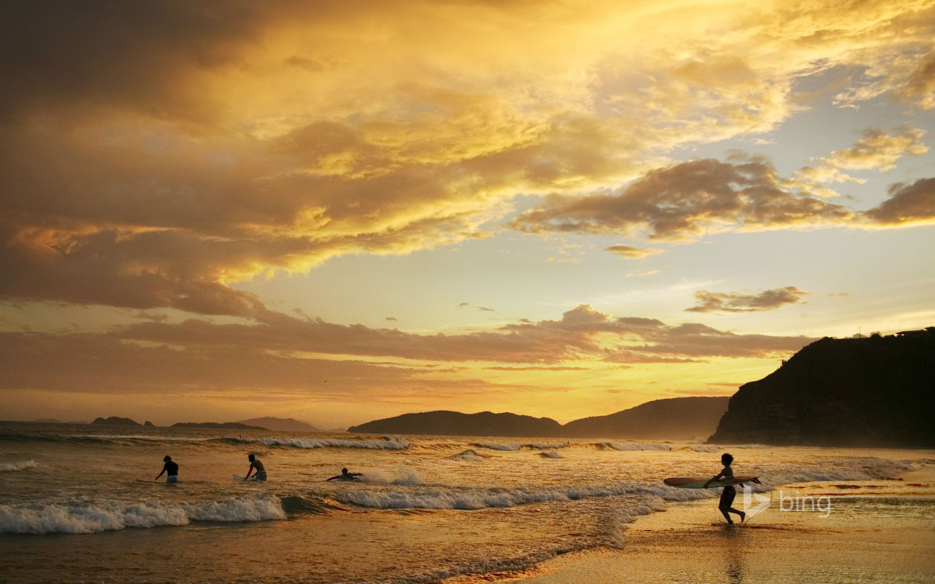 People surfing at dusk, Geriba Beach, Buzios, Brazil